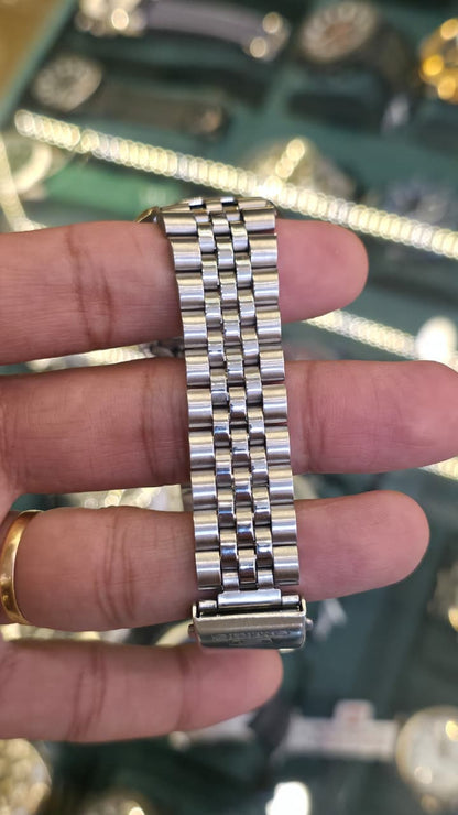 Seiko 5 Automatic watch featuring a silver-tone stainless steel bracelet and a white textured dial with gold-tone indices.