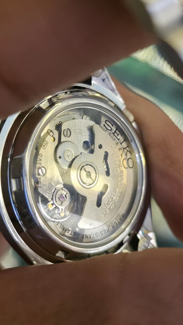 Seiko 5 Automatic watch featuring a silver-tone stainless steel bracelet and a white textured dial with gold-tone indices.