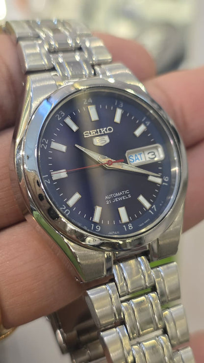 Seiko 5 automatic watch featuring a striking blue dial with an inner 24-hour track and a day-date